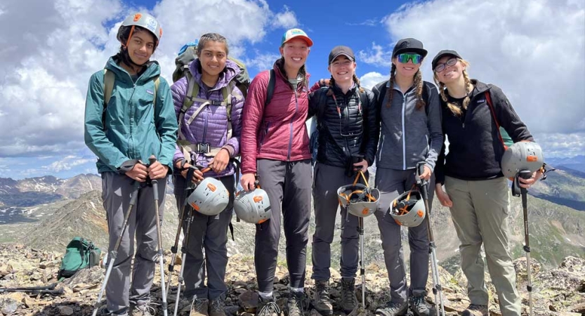 A group of people pose for a photo in a rocky landscape 
